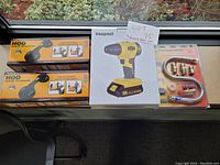 Photo showing two HOD Handle on Demand tools, Veapoot cordless impact driver box, and the Universal Appliance Hook-Up Kit on a table near a window.