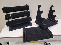 One costume jewellery bracelet and three black velvet adjustable height jewellery displays, displayed unfolded and folded flat for transport/ storage.