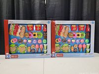 Two sealed toy food play sets side by side showing all included items in the box under brand Chef, age 3+