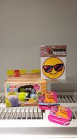 Full lot display including Ugly Dolls Squish & Go box, Style Lab smile patch, and Trolls accessories on a white rack.