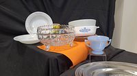 Side angle showing white plates, Federal Glass footed bowl, Pyrex sugar bowl, CorningWare dish, and metal trays.