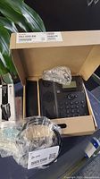 Polycom Edge 830 telephone in original box with wrapped handset and quick start guide.