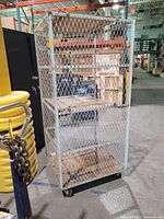 Full view of the metal pick and pack cart showing two wooden platforms and metal cage sides.