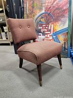 Front angle view of pink slipper chair showing upholstery and legs