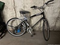 Full side view of black Eastwood KHS bicycle with plastic-wrapped seat, visible tires, and handlebar grips.