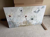 Full view of floral canvas painting showing white flowers with textured paint on a muted beige and gray background.