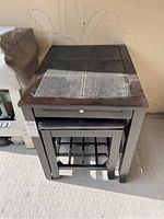 Wooden end table with leather-like top viewed from above, showing wear and the pull-out tray below the top.