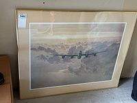 Front view of framed aircraft print showing entire artwork and frame, with light reflections visible on glass.