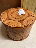 Top view of the round leather pouf showing embossed elephant motif and circular patterns with natural tan and brown leather tones.
