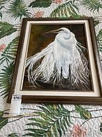 Full view of framed acrylic painting of a white egret with flowing feathers on a dark background, showing signature and frame detail.