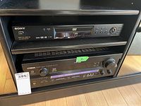 Yamaha RX-V740 AV Receiver and Sony DVD/CD/Video CD player in a black AV cabinet shelf