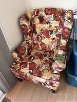 Full view of floral wingback chair showing fabric pattern and chair shape.