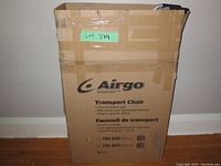 Cardboard shipping box labeled Airgo Transport Chair, model 700-855, with product features and weight capacity printed on the box.
