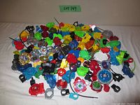 Wide view of all Beyblade tops, launchers, ripcords, and parts spread on surface