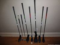 Full lineup of eight clubs leaning against wall on hardwood floor