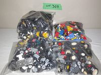 Four plastic bags containing assorted genuine LEGO wheels, tires and vehicle parts, in various colors and sizes.