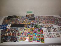 Wide view of a variety of trading cards laid out on table showing sports cards, garbage pail kids, and game cards spread across the surface.