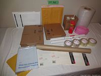 Lot showing entire array of shipping supplies including envelopes, boxes, bubble wrap, tape, dispenser, and tubes