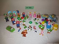 Photo showing the full collection of Super Mario Bros themed toys spread on a surface with characters and blocks arranged generally grouped by type.