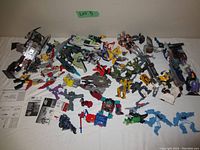 Full view of all Transformers toys and related manuals spread on white surface.
