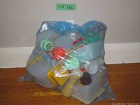 Image of assorted Tupperware items packaged together in a plastic bag showing variety of kitchen utensils and containers.