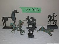 All seven bronze Greek reproduction figures displayed together, showing scale and variety.