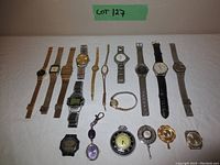 Full lot showing 16 watch and watch accessory items lined up on white background with 'Lot 127' label above.