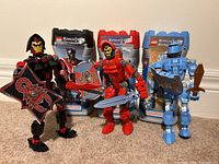 Three Lego Knights Kingdom figures posed with their original packaging behind. Each figure holds weapons and shields with visible detailing.