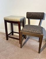 View of the Mid-Century Modern wooden chair alongside the cushioned wooden stool on carpeted floor against a plain background.