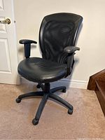 Full view of black adjustable office chair with mesh back and leather seat, showing five-wheel base and armrests.