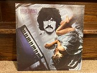 Front of the album cover sleeve with album art showing Burton Cummings and a seated woman with a piano keyboard graphic.