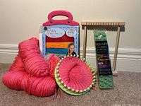 Photo showing entire lot: pink yarn skein, Leg Warminators leg warmer loom kit in plastic package, pink circular loom with pink yarn in progress, wooden rectangular loom, and Krazy Looms bracelet kit in green packaging.