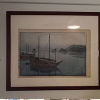 Front view of framed woodblock print showing boat and island scene