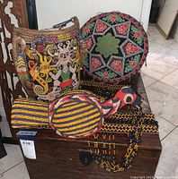 Overall view of backpack, hat, bird figurine, necklace and band on wooden surface