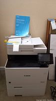 Full view of the Canon Color ImageCLASS printer with the Getting Started manual placed on top.