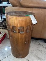 Front view of hand carved tree trunk table showing the smooth top and carved rectangular details near the top circumference.
