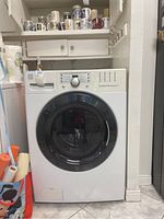 Front view of white Kenmore front load washer with visible control panel and door window.