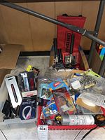 Wide view showing assorted hand tools, hardware, and packaged items including door handles and small tools.