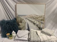 Full lot setup showing bedding, decor pillow, Buddha statue, succulent, candle, and large framed dune walkway artwork.