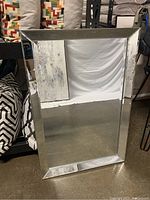 Rectangular mirror showing full front view of reflective surface and beveled edge frame.
