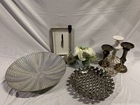 Shows the full lot including both decorative bowls, candlesticks, framed feather art, glass vase with black olive leaves, white artificial flowers, and brass wire sphere