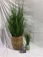 Full view of the large and small faux grass plants with the solar light string box in front, staged against white background.