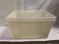 Clear rectangular plastic storage bin shown from the side, empty inside, with integrated handles, slightly frosted clear plastic.