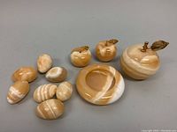 Full lot display showing two-piece apple box, smaller apples, ashtray, and nine egg figurines arranged on surface.