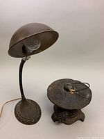 Lamp and lantern side by side, showing base of lamp and top of lantern