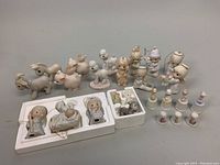 Photo of entire assortment of vintage Christmas figurines arranged on table with some in foam packaging.