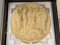 Image of one alabaster bas-relief plate showing a religious scene with figures in robes arranged in a group and a figure lying on the ground at the front.