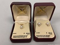 Necklace and earrings displayed in their red jewelry boxes