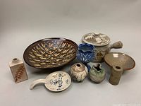 Overview photo showing all 10 pottery pieces in the lot, including large serving bowl, covered pot, small vases, and vessels.