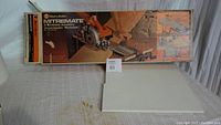 Photo showing original packaging and the Mitremate accessory inside its box with setup instructions and illustrations visible on box top